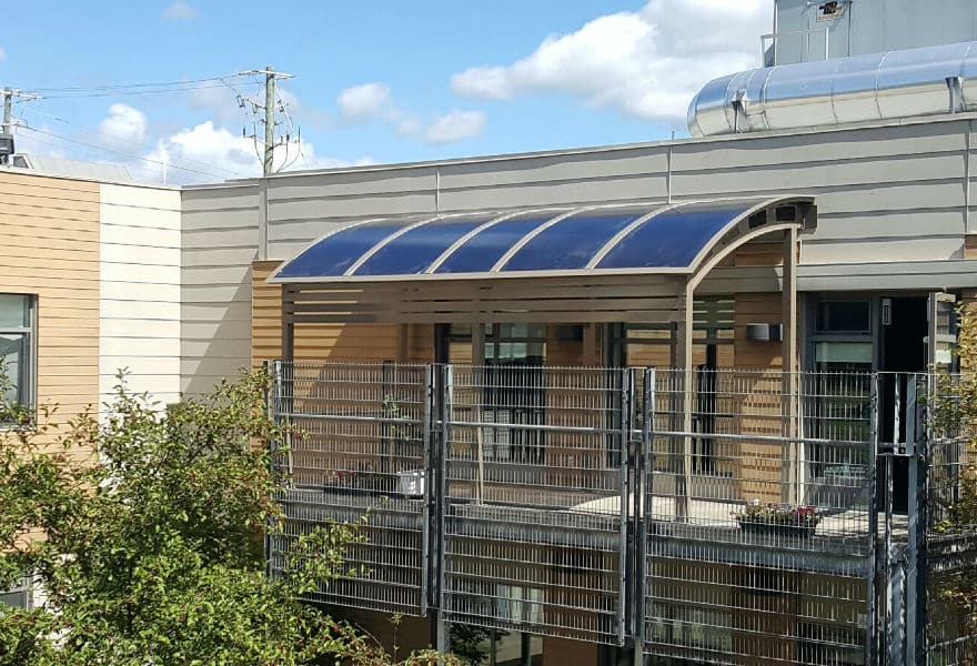 Abri_terrasse_et_abri_demployes_42 Vue aérienne portique d'entrée avec toiture polycarbonate